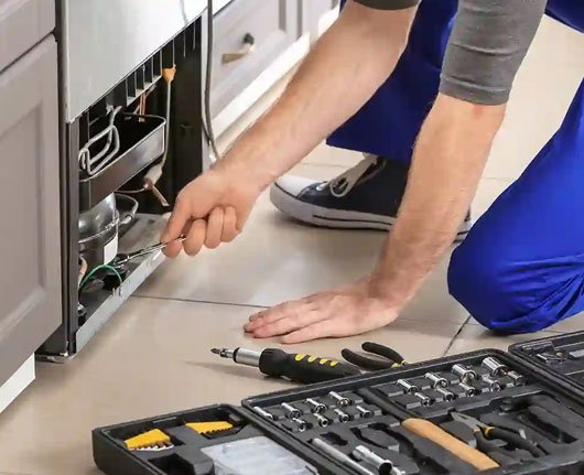 Appliance repair service areas in Orange County – technician repairing a refrigerator