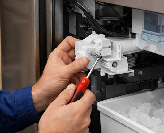 Hands of a technician fixing internal components during ice maker repair near me