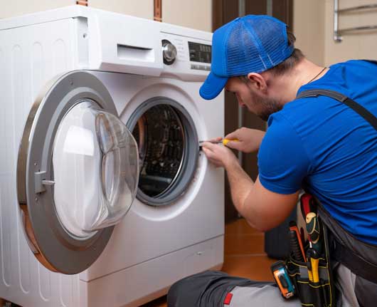 Technician performing washer repair Orange County in a residential laundry room