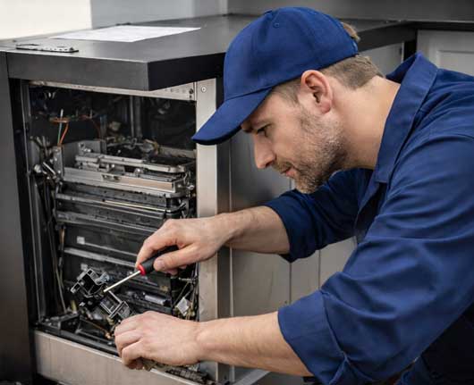 Technician performing Trash Compactor repair Orange County in a residential kitchen setting