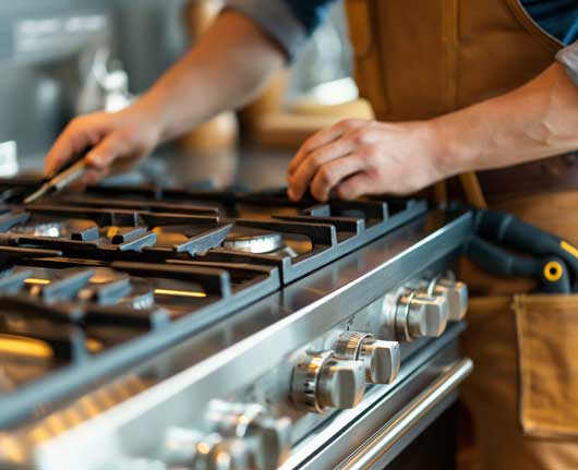 Technician performing range repair Orange County on a residential kitchen range
