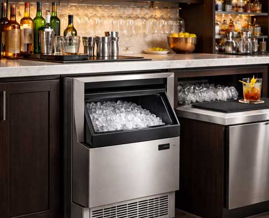Commercial ice maker installed behind a bar counter in a modern restaurant illustrating emergency appliance service in Costa Mesa